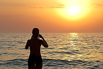 Girl silhouette and sunset on the sea