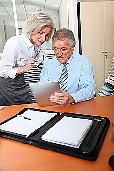 Senior business people in the office with electronic pad