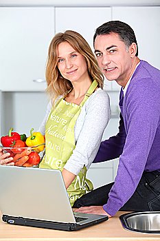 Couple in kitchen looking for cooking receipe