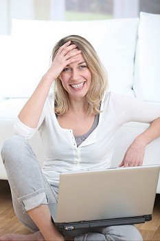 Happy woman using laptop computer at home