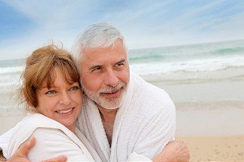 Senior couple at the beach with spa bathrobe