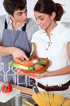 Young smiling couple standing in home kitchen