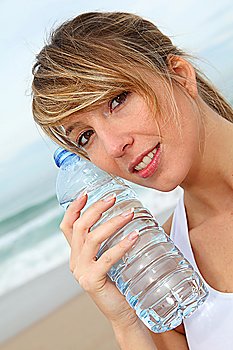 Closeup of beautiful woman drinking water from bottle