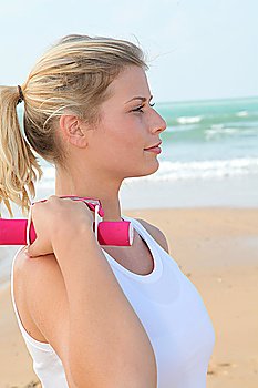 Young woman exercising by the beach