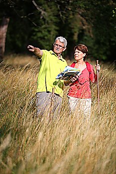 Senior couple rampling in countryside with map