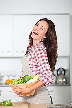 Beautiful woman stading in kitchen with apron