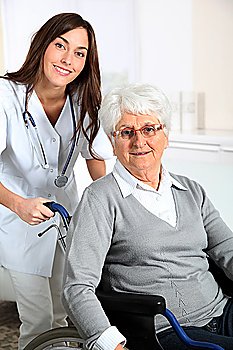 Elderly woman in wheelchair with nurse at home