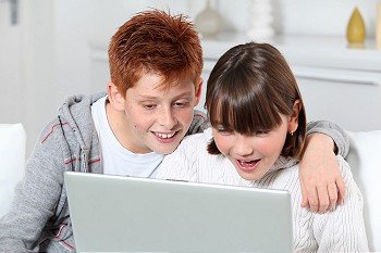 Young boy and girl at home with laptop