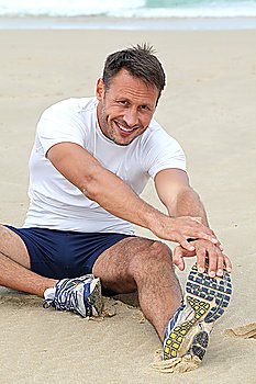 Man stretching on the beach