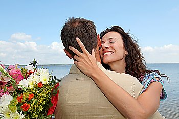 Man surprising woman with bunch of flowers
