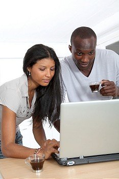Young couple with laptop computer in home kitchen