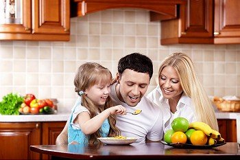 The young family has breakfast with the child on kitchen