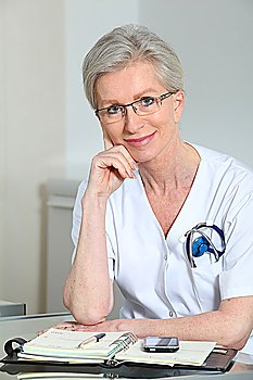 Portrait of smiling mature nurse in office