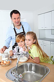 Father and children preparing pancakes