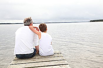 Portrait of father and son sitting on a pontoon