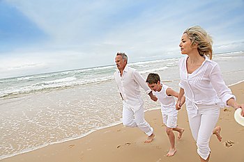 Family running on a sandy beach