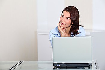 Portrait of businesswoman in front of laptop computer