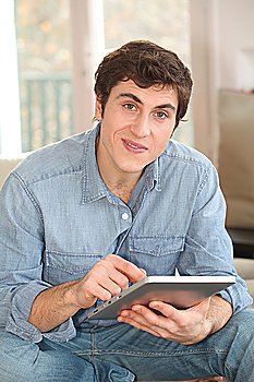 Man using electronic tablet at home