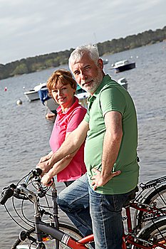 Senior couple on bicycle ride by a lakeside