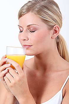 Beautiful blond woman holding glass of orange juice