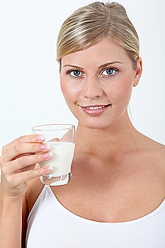 Beautiful blond woman holding glass of milk
