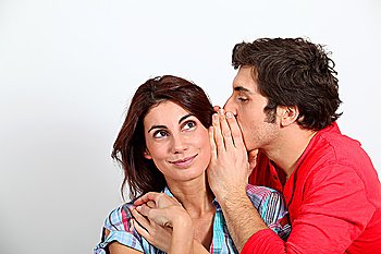 Young man whispering in his girlfriend´s ear