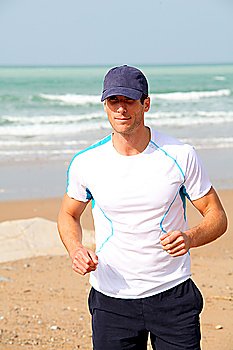 Athletic man running by the sea in summer