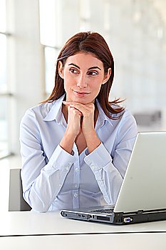 Beautiful office worker sitting at her desk