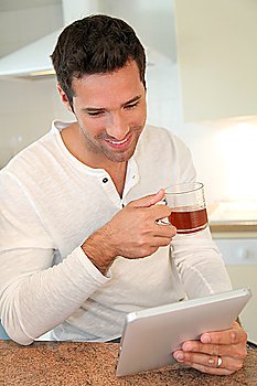 Portrait of man in kitchen drinking tea