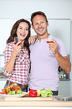 Couple drinking wine while fixing dinner