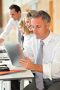 Office worker looking at internet on electronic pad