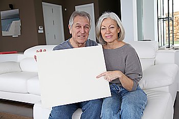 Senior couple holding message board