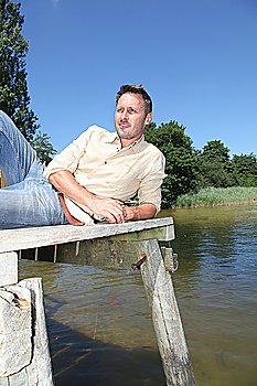 Man resting on a pontoon by a lake