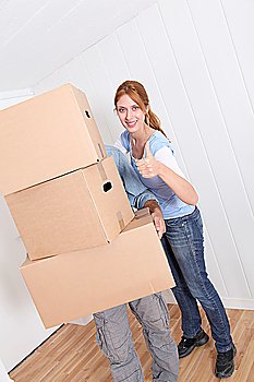 Couple carrying boxes to move in new house