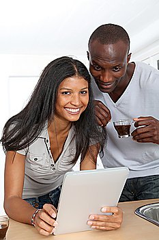 Young couple using electronic pad in kitchen