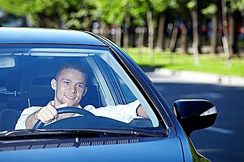 A young-looking man driving a car