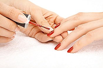 Process of drawing red varnish on the female nails, isolated