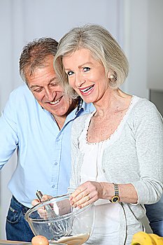 Senior couple in kitchen baking cake