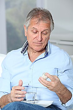 Senior man taking medicine