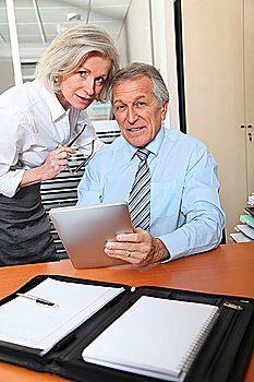 Senior business people in the office with electronic pad