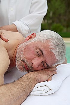 Portrait of senior man laying on a massage bed