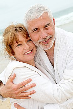 Senior couple at the beach with spa bathrobe