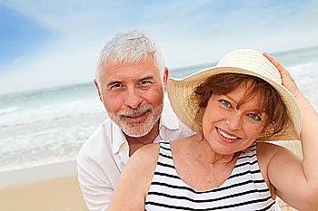 Portrait of happy senior couple on a sandy beach
