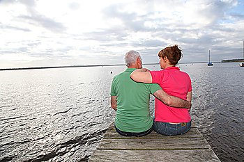 Back view of senior couple sitting on a pontoon