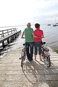 Senior couple on bicycle ride by a lakeside