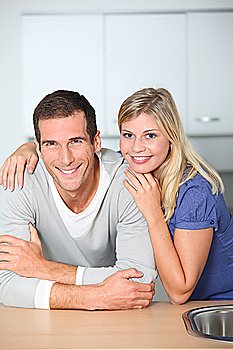 Smiling couple standing in home kitchen