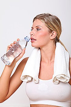 Blond woman drinking water after exercising