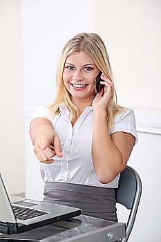 Blond businesswoman pointing at camera