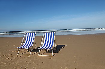 Closeup of deckchairs on sandy beach