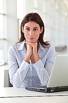 Beautiful office worker sitting at her desk